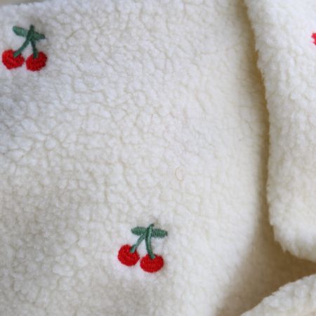 Teddy / moumoute bouclé fond écru broderies cerises