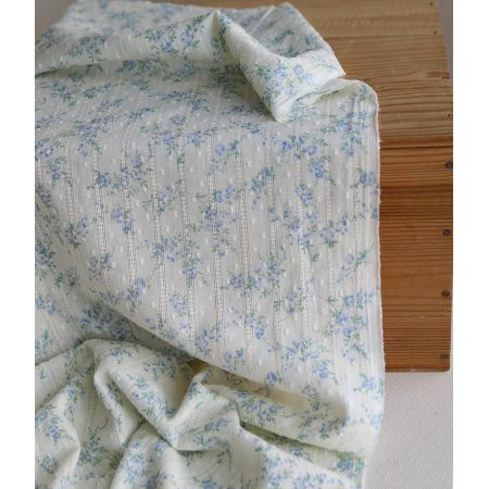 Broderie anglaise plumetis en coton imprimé fleuri bleu sur fond écru