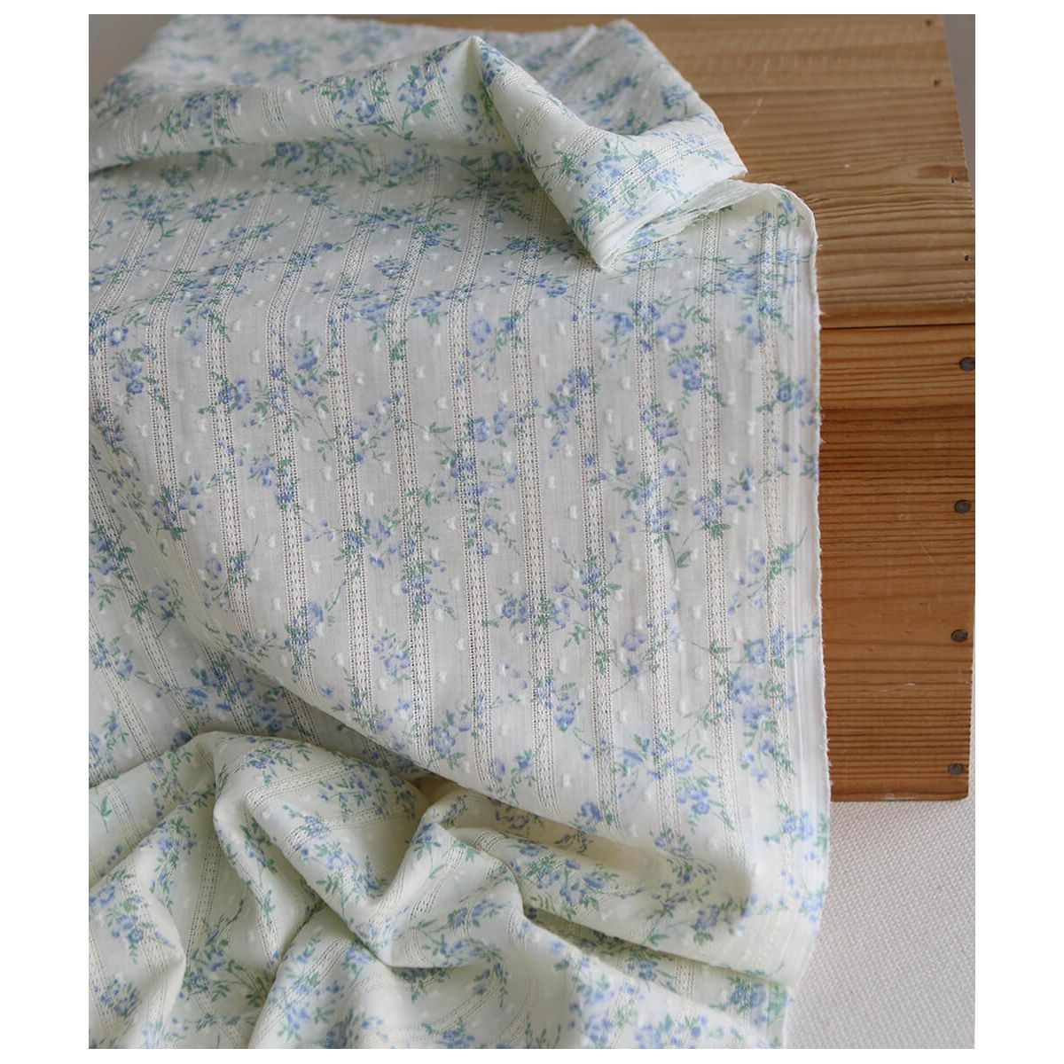 Broderie anglaise plumetis en coton imprimé fleuri bleu sur fond écru