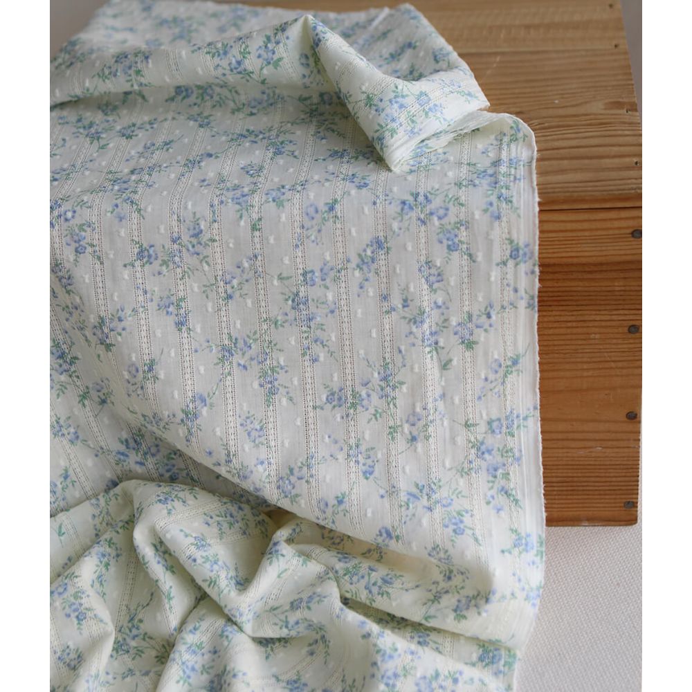 Broderie anglaise plumetis en coton imprimé fleuri bleu sur fond écru