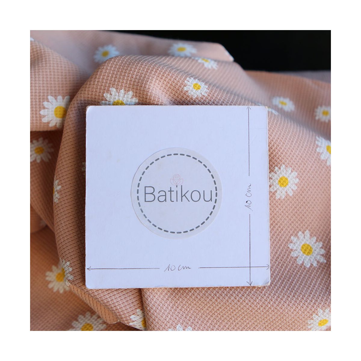 Jersey coton côtes fines à motif marguerites sur fond pêche nude