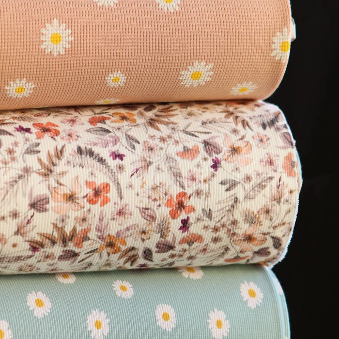 Jersey coton côtes fines à motif marguerites sur fond pêche nude