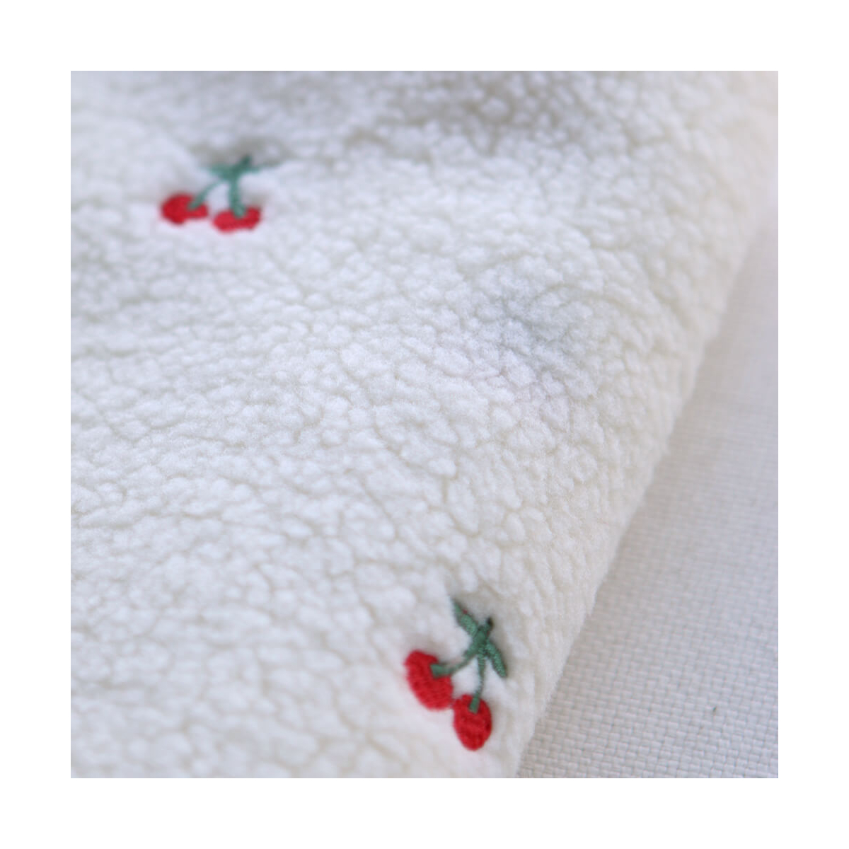 Teddy / moumoute bouclé fond écru broderies cerises