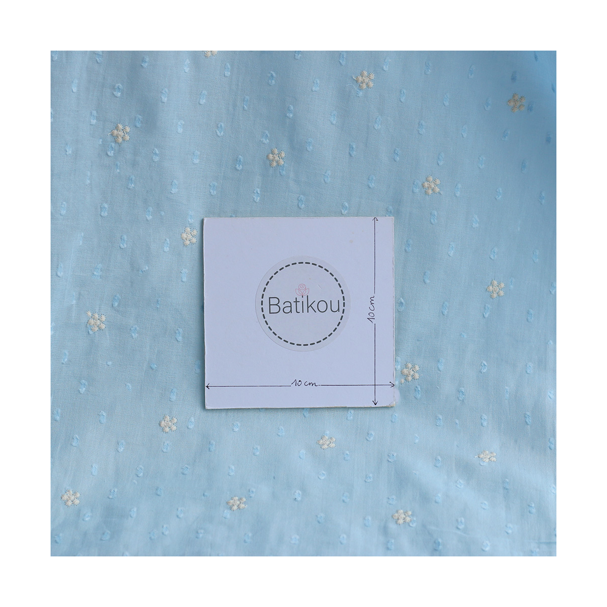Voile plumetis de coton broderies motif crème coloris bleu ciel