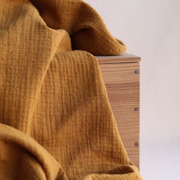 Double gaze de coton bio à plumetis coloris curry moutarde, tissu doux pour bébé