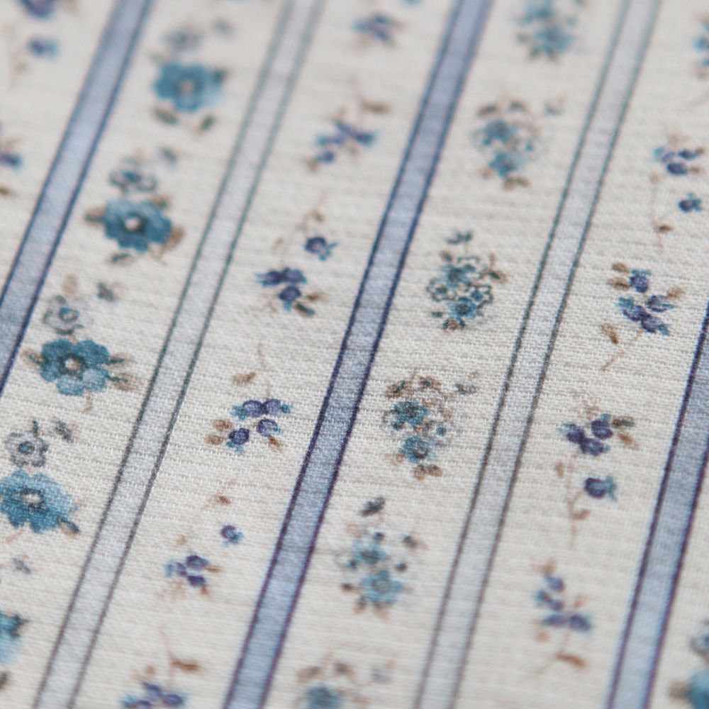 Détail du petit piqué gratté bio Paloma, semis fleuri bleu entre rayures