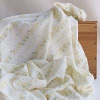 Camille - Tissu coton jacquard seersucker fond écru fleuri jaune clair