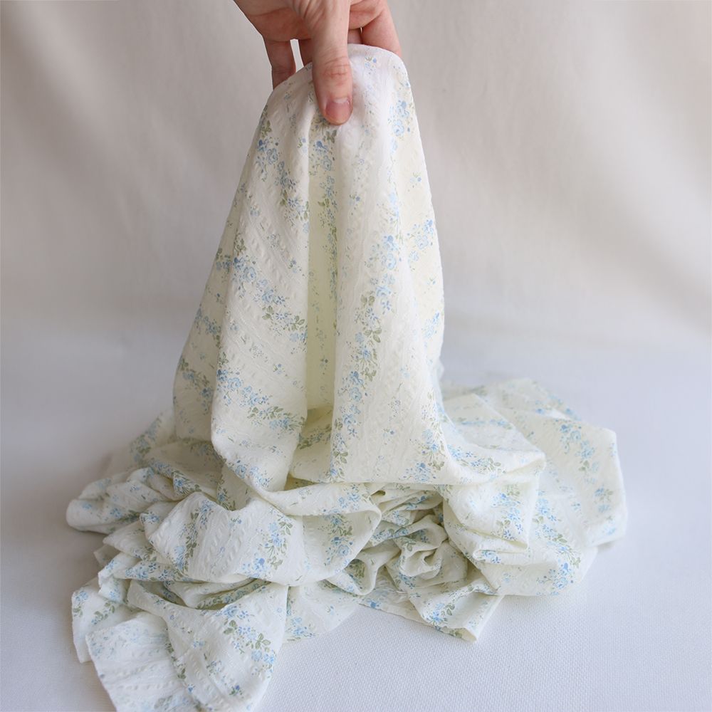 Camille - Tissu coton jacquard seersucker fond écru fleuri bleu clair