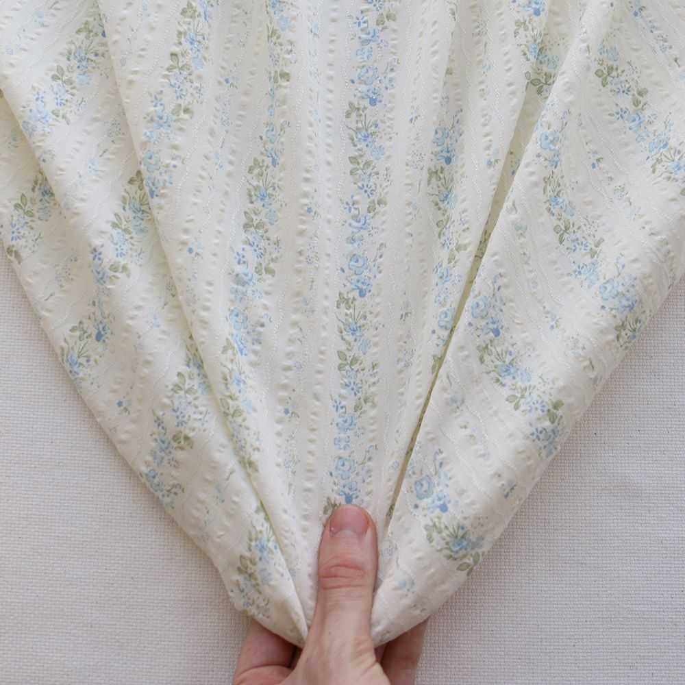 Camille - Tissu coton jacquard seersucker fond écru fleuri bleu clair