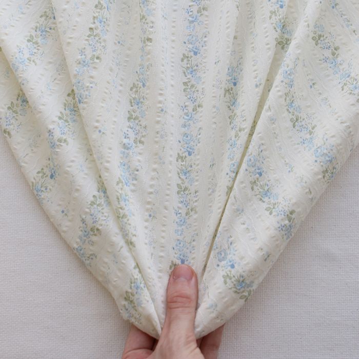 Camille - Tissu coton jacquard seersucker fond écru fleuri bleu clair