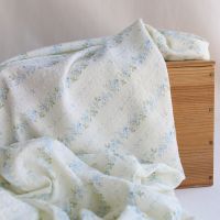 Camille - Tissu coton jacquard seersucker fond écru fleuri bleu clair