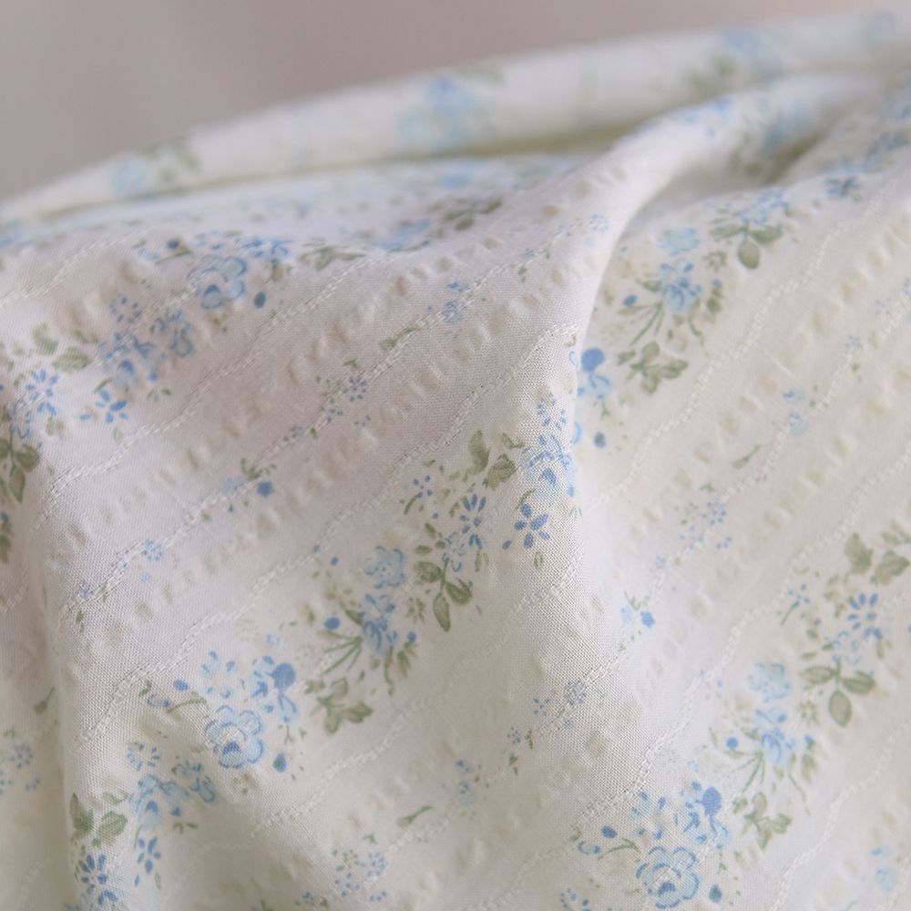 Camille - Tissu coton jacquard seersucker fond écru fleuri bleu clair
