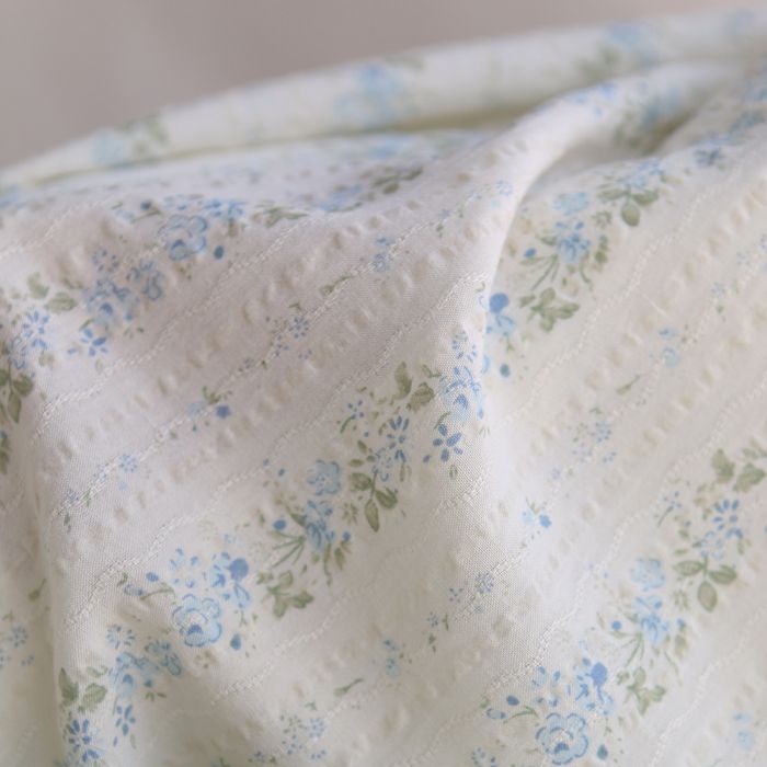 Camille - Tissu coton jacquard seersucker fond écru fleuri bleu clair