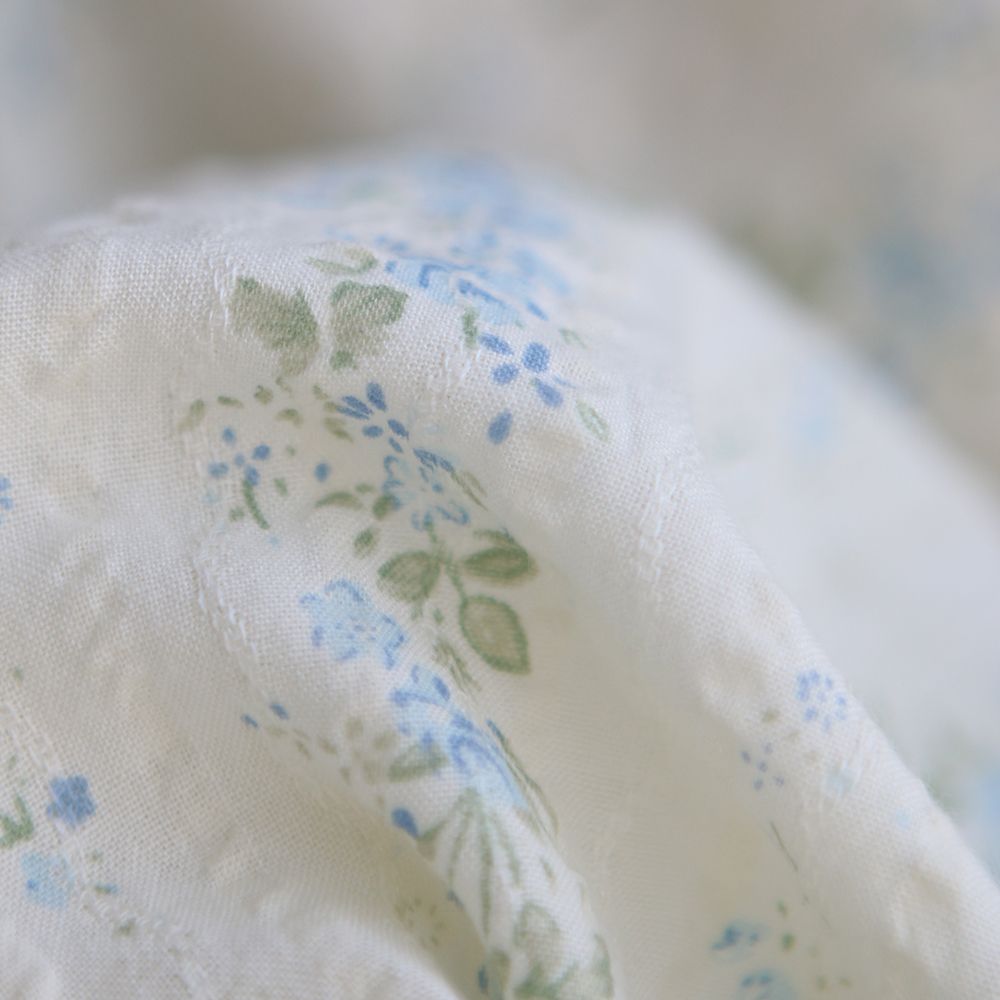 Camille - Tissu coton jacquard seersucker fond écru fleuri bleu clair