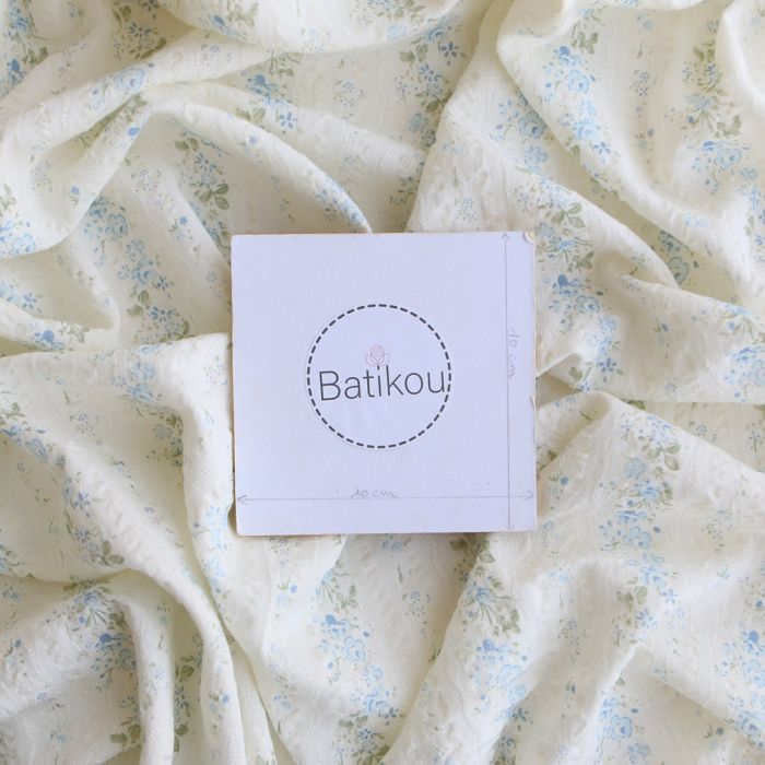 Camille - Tissu coton jacquard seersucker fond écru fleuri bleu clair