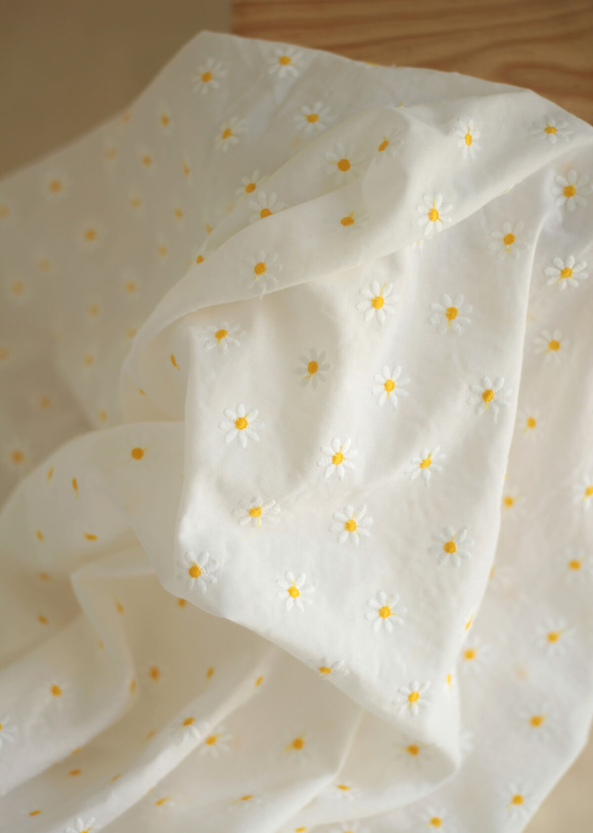 Batiste de coton blanc broderies petites pâquerettes