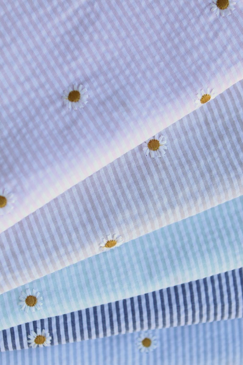 Seersucker / Coton gaufré rayé blanc et bleu marine broderie marguerite