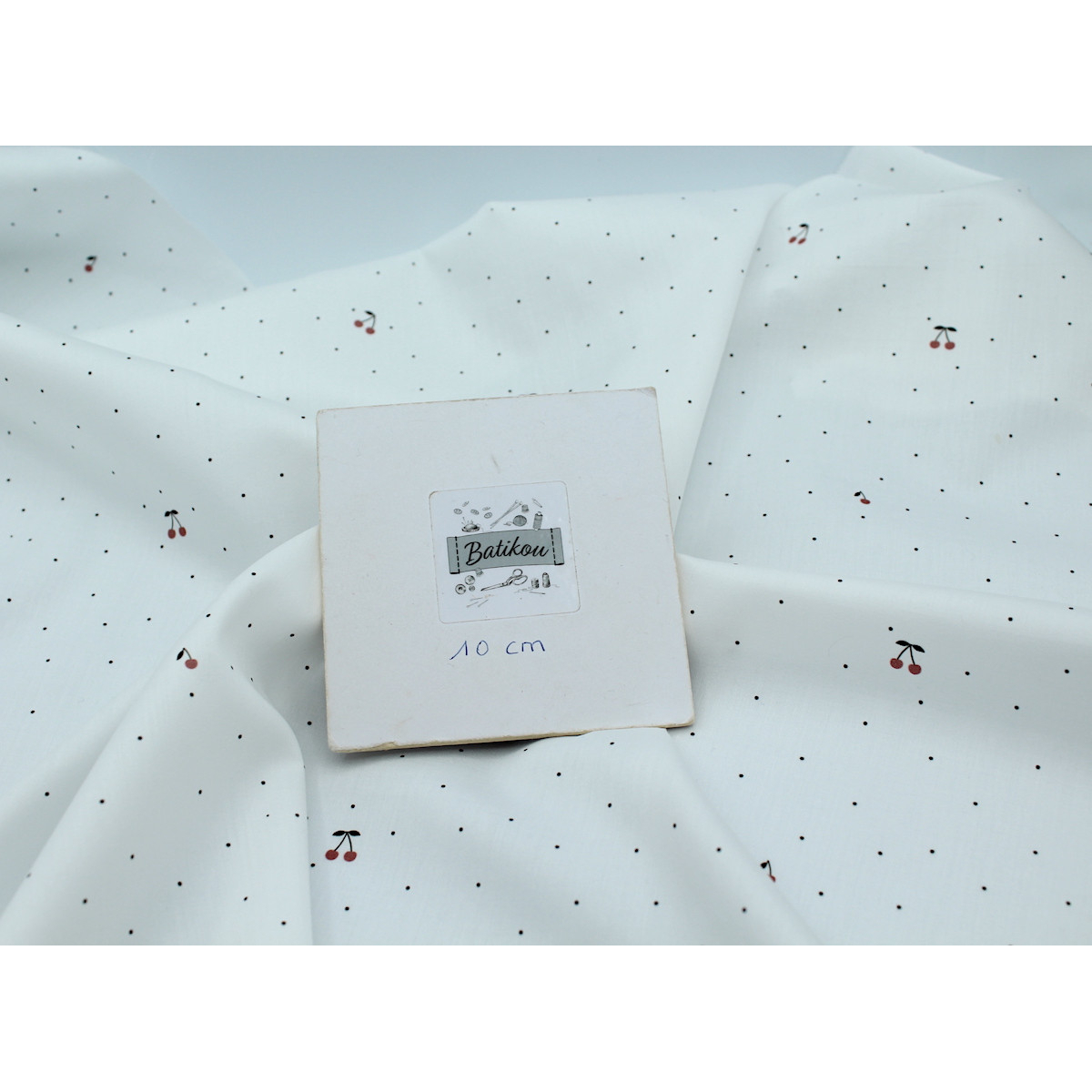 Coton satiné motif Cherries exclusif Batikou fond blanc lait x1m Coton satiné motif Cherries exclusif Batikou fond blanc lait x1m