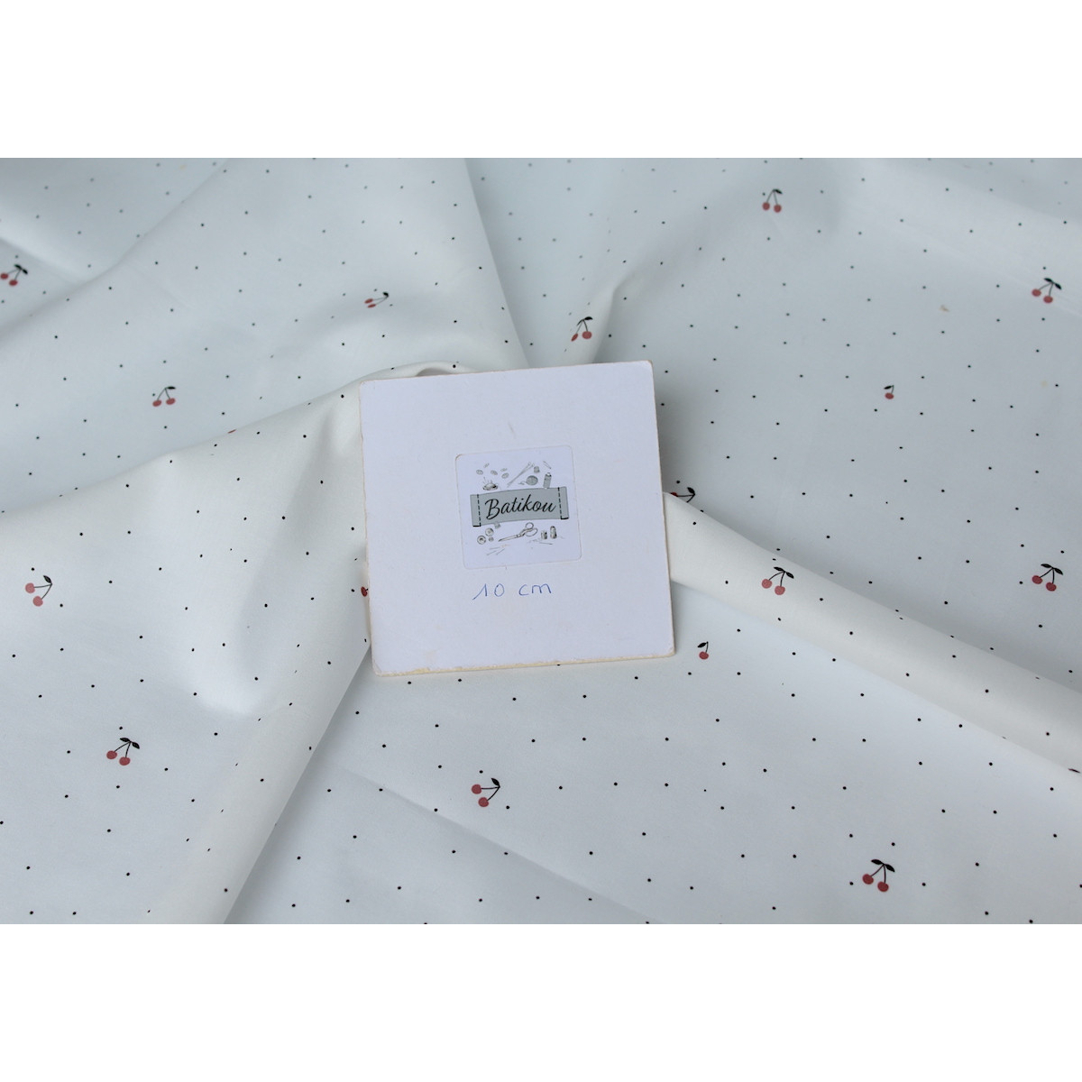 Coton satiné motif Cherries exclusif Batikou fond blanc lait x1m Coton satiné motif Cherries exclusif Batikou fond blanc lait x1m