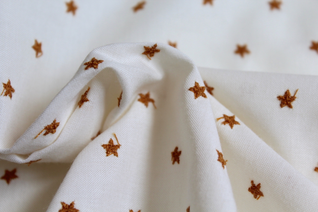 Tissu coton organique broderies étoiles moutarde