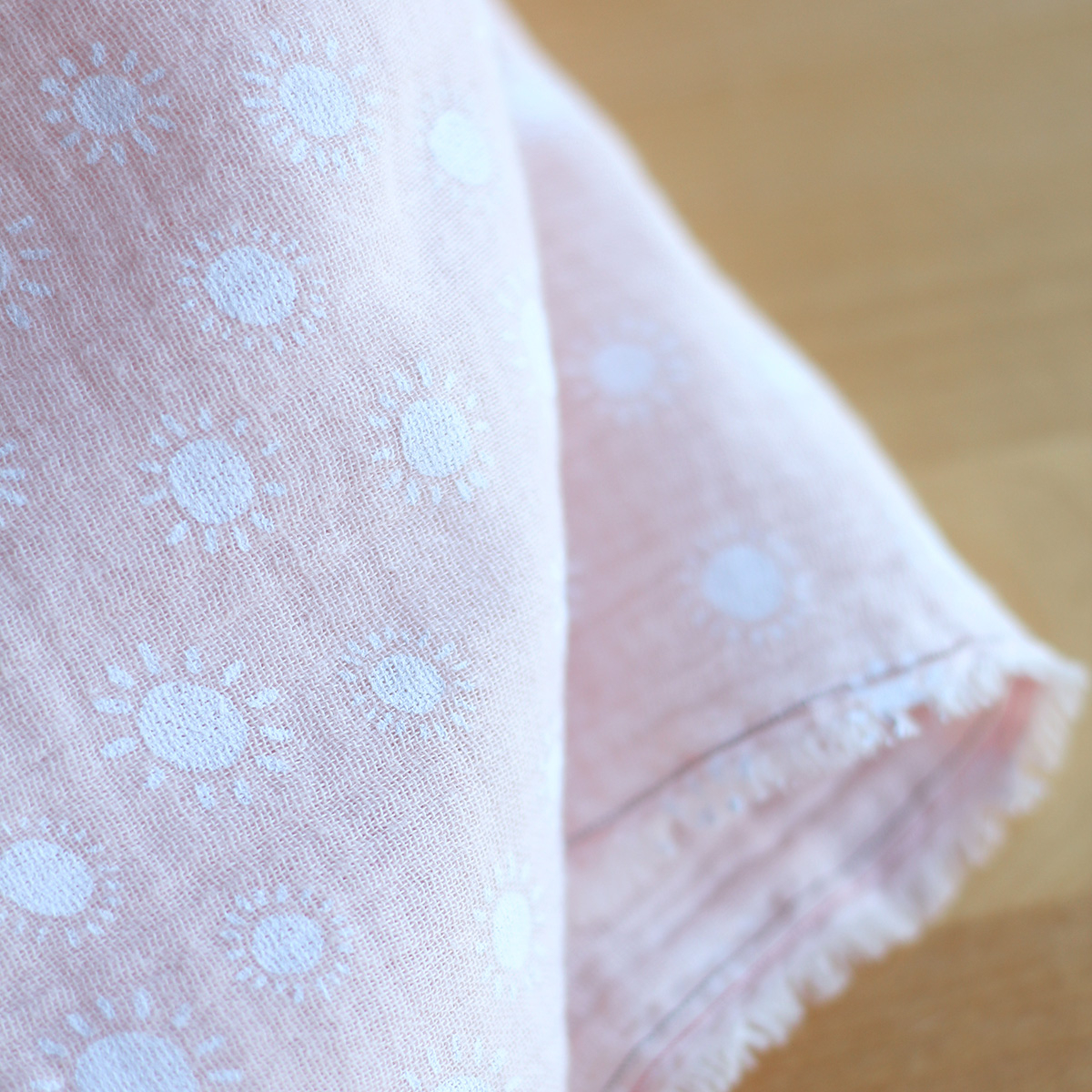 Solea - Double gaze de coton coloris fond rose nude motif soleil Solea - Double gaze de coton coloris fond rose nude motif soleil
