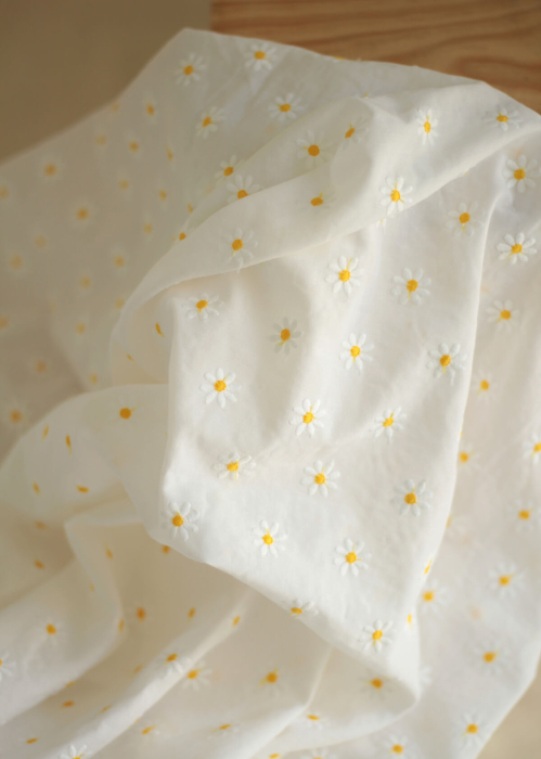 Batiste de coton blanc broderies petites pâquerettes