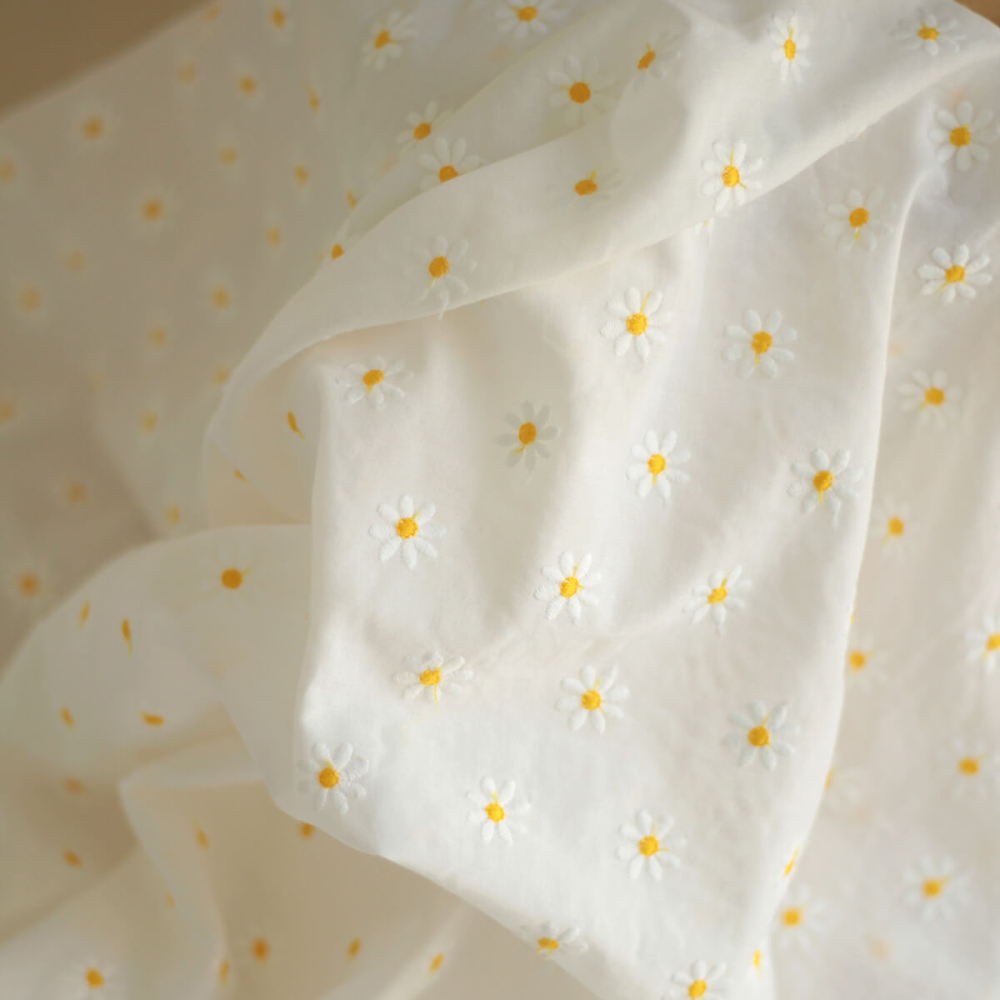 Batiste de coton blanc broderies petites pâquerettes