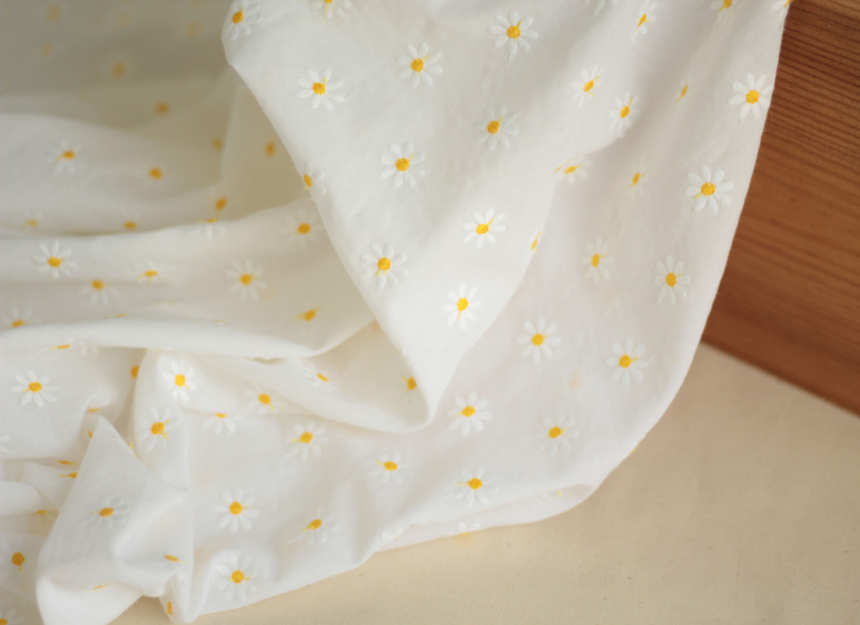 Batiste de coton blanc broderies petites pâquerettes