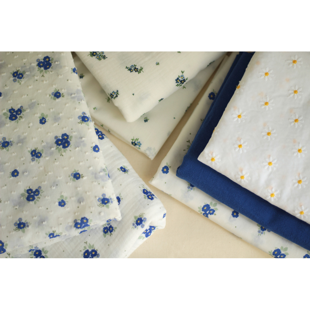 Batiste de coton blanc broderies petites pâquerettes