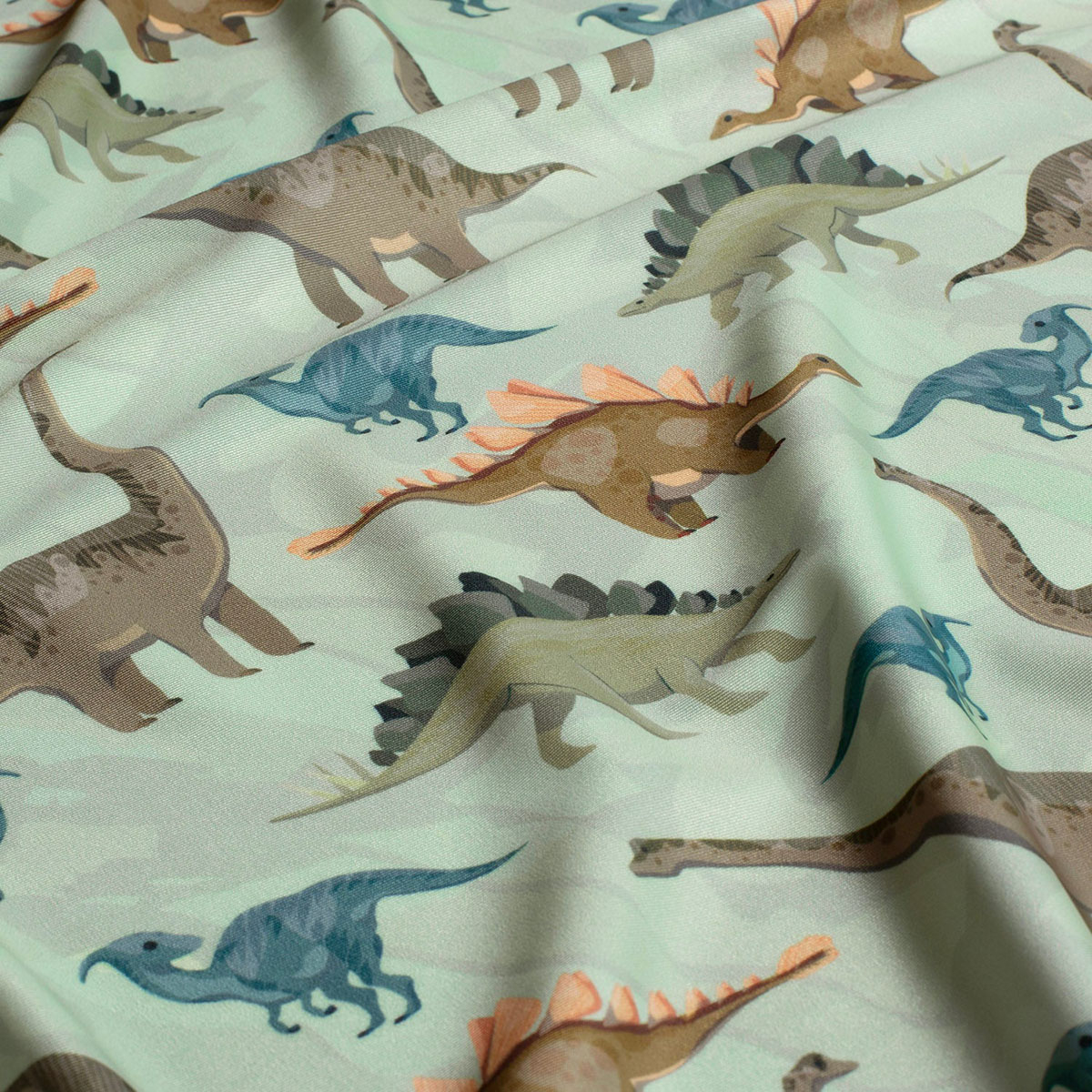 Tissu Lycra (maillot de bain) UPF50 dinosaures sur fond vert clair Tissu Lycra (maillot de bain) UPF50 dinosaures sur fond vert clair