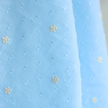 Voile plumetis de coton broderies motif crème coloris bleu ciel Voile plumetis de coton broderies motif crème coloris bleu ciel