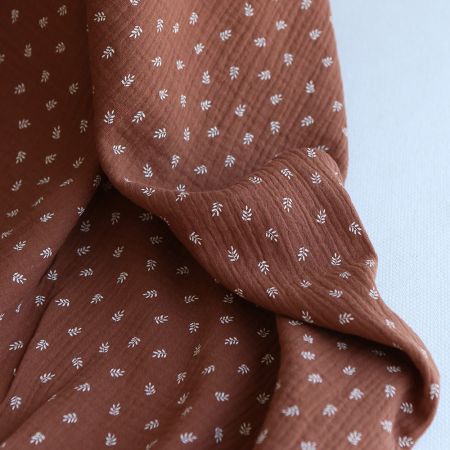 Sacha - Double gaze de coton motif feuilles fond noisette Sacha - Double gaze de coton motif feuilles fond noisette