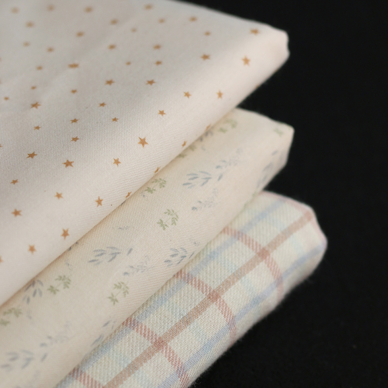 Star - Popeline douce coton organique fond ivoire petites étoiles moutarde