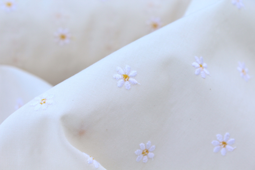 Tissu coton organique broderies fleurs pâquerettes