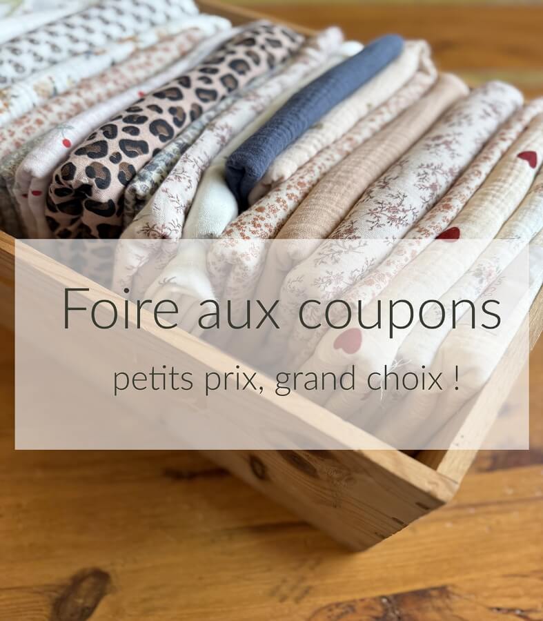 Foire aux coupons Batikou — pile de tissus pliés, motifs floraux et tons poudrés